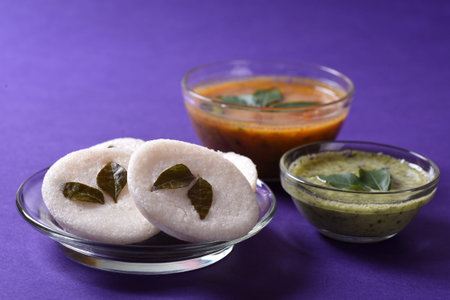 Idli with Sambar and coconut chutney on violet background, Indian Dish : south Indian favourite food rava idli or semolina idly or rava idly, served with sambar and green chutney.の写真素材