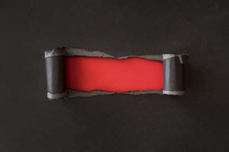 abstract torn black paper revealing red paper. High quality and resolution beautiful photo conceptの写真素材