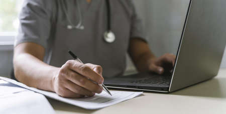 side view doctor with stethoscope working laptop writing paper . High quality and resolution beautiful photo conceptの写真素材