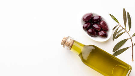 olive oil bottle with leaves purple olives with copy spaceの写真素材