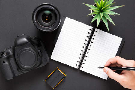 flat lay camera lenses notebook black backgroundの写真素材