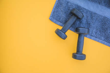 dumbbells towel yellow background. High quality and resolution beautiful photo conceptの写真素材