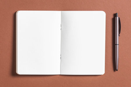 open blank book with pen brown background