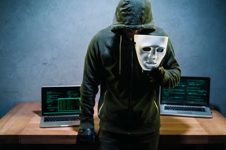 hacker holding maskの写真素材