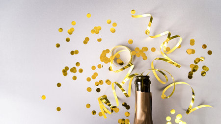 champagne bottle with golden confetti streamers white background. High quality and resolution beautiful photo conceptの写真素材