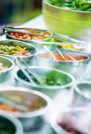 bowls of mixed fresh organic vegetables in salad bar displayの写真素材