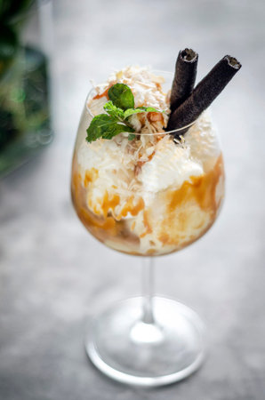 coconut and caramel ice cream sundae dessert in wine glassの写真素材