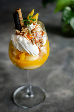 mango and passion fruit tropical ice cream sundae in glassの写真素材