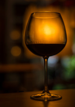 glass of red wine in dark cozy bar interiorの写真素材