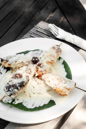 fish skewers with creamy coconut sauce and rice in vietnamの写真素材