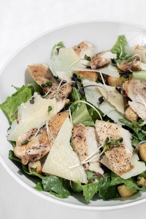 organic chicken caesar salad with parmesan cheese and croutonsの写真素材