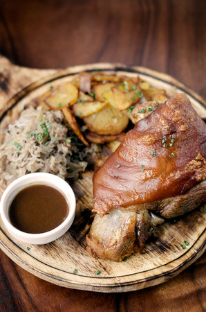 SCHWEINSHAXE traditional german pork knuckle with sauerkraut and potatoes meal
