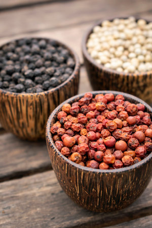 Organic white red and black pepper corns in wood display