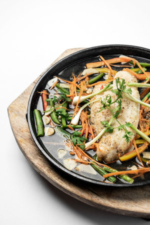 chinese style steamed fish fillet with vegetables on hot plateの写真素材