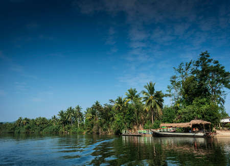 traditional jungle boat at pier on tatai river in cambodiaの写真素材