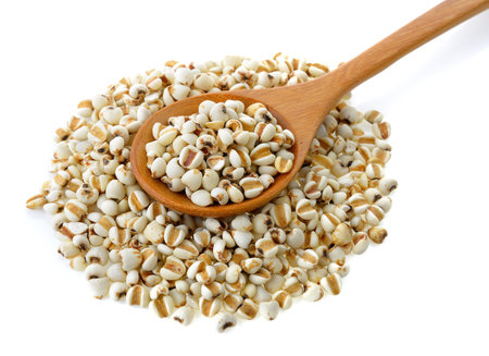 Millet in wood spoon isolated on white background