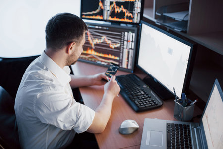 Using modern technologies at work. Young businessman working on digital tablet while sitting at the desk in creative officeの写真素材