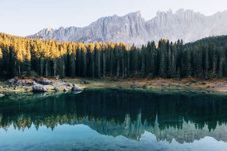 Autumn landscape with clear lake, fir forest and majestic mountainsの写真素材