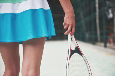 Beautiful tennis legs on the court with a racquet.の写真素材