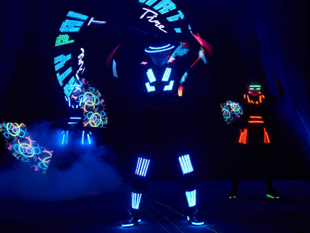 Laser show performance, dancers in led suits with LED lamp, very beautiful night club performance, partyの写真素材