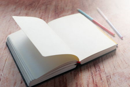 open book and a pencil on wooden table.
