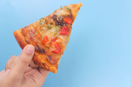 top view of man hand picking slice of pizza from a plate .