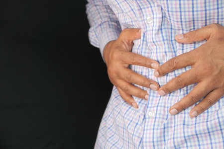 young man suffering stomach pain close upの写真素材