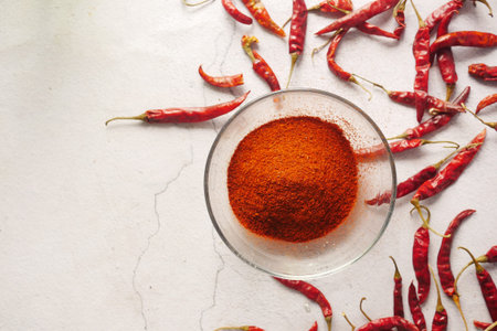 Chili powder and dried peppers on white backgroundの写真素材