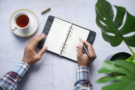 Close up of man hand writing on notepad