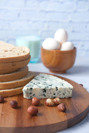 blue cheese , egg , milk and f brown bread on table .
