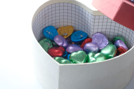 small heart shape gift with candy on white background .