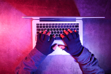 hacker hand stealing data from laptop top down.