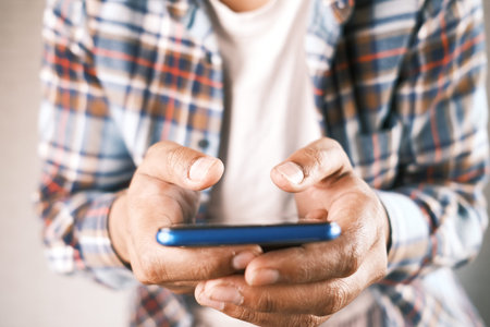 Close up of young man hand using smart phone
