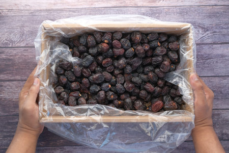 the concept of ramadan, hand holding a bowl of date fruits .