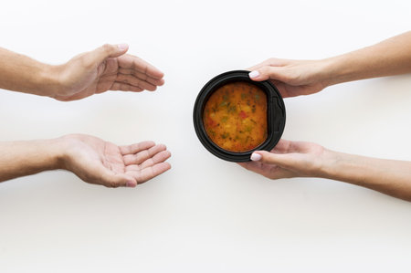 hand giving bowl soup needy person. Resolution and high quality beautiful photo