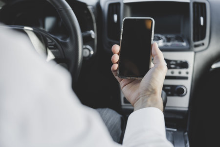 close up man s hand holding mobile phone with blank screen car. Resolution and high quality...