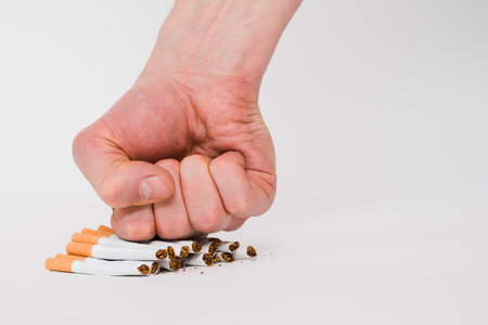 person fist crushing cigarettes isolated white backgroundの写真素材