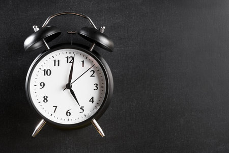 alarm clock showing 5 o clock against black background. Resolution and high quality beautiful photo