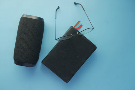 smart speaker and book on blue background .