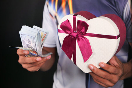 young man hand holding gift box and cashの写真素材