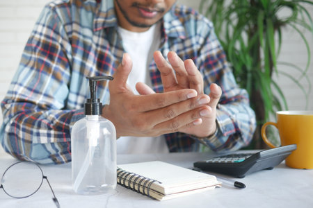 young man using hand sanitizer white sited ,の写真素材