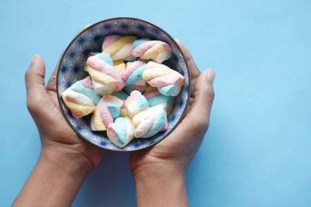 marshmallow candy in a bowl on blue .
