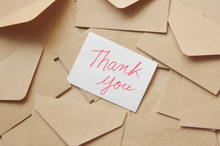 thank you message and envelope on wooden table.の写真素材