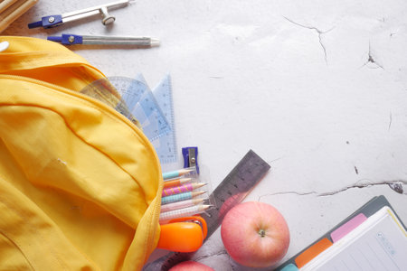 back to school concept with yellow backpack and school suppliers on table.の写真素材