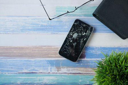 Top view of broken smart phone on color background.の写真素材