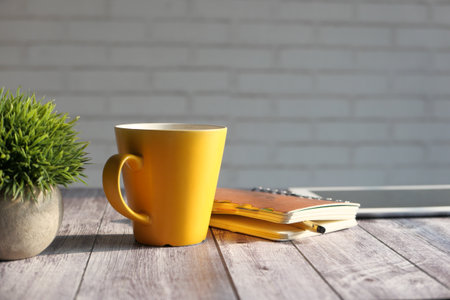 laptop, yellow color coffee mug on table .の写真素材