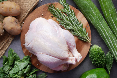 raw whole chicken and green vegetables on table, top view ,の写真素材