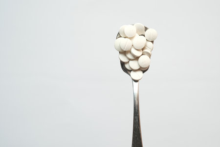 high angle view of pills on spoon on white , top view .の写真素材