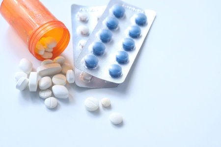 selective focus. close up of colorful pills spilling on white background.