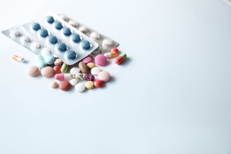 close up of colorful pills spilling on white background.の写真素材